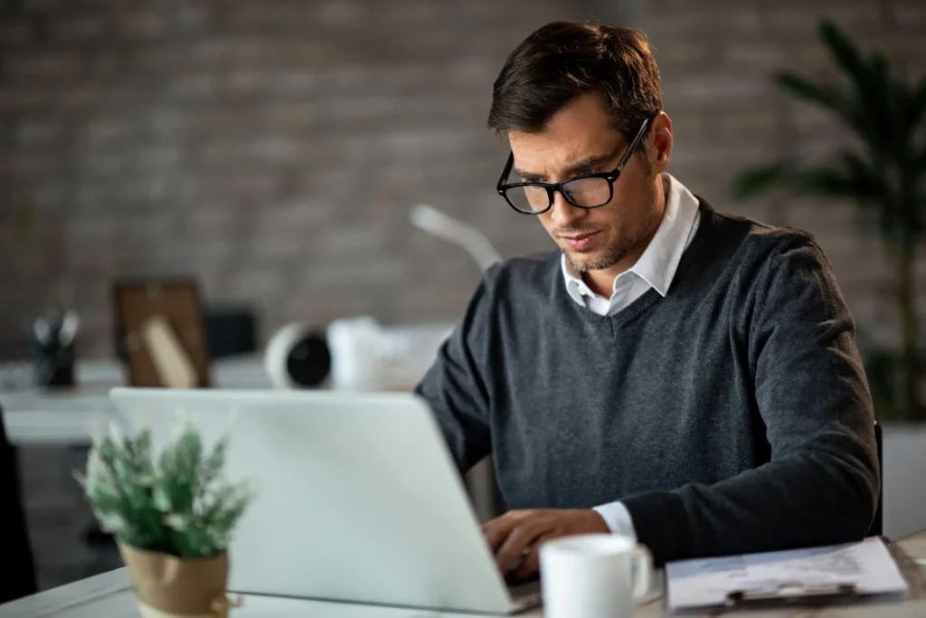 Young entrepreneur navigating a website reading the faq