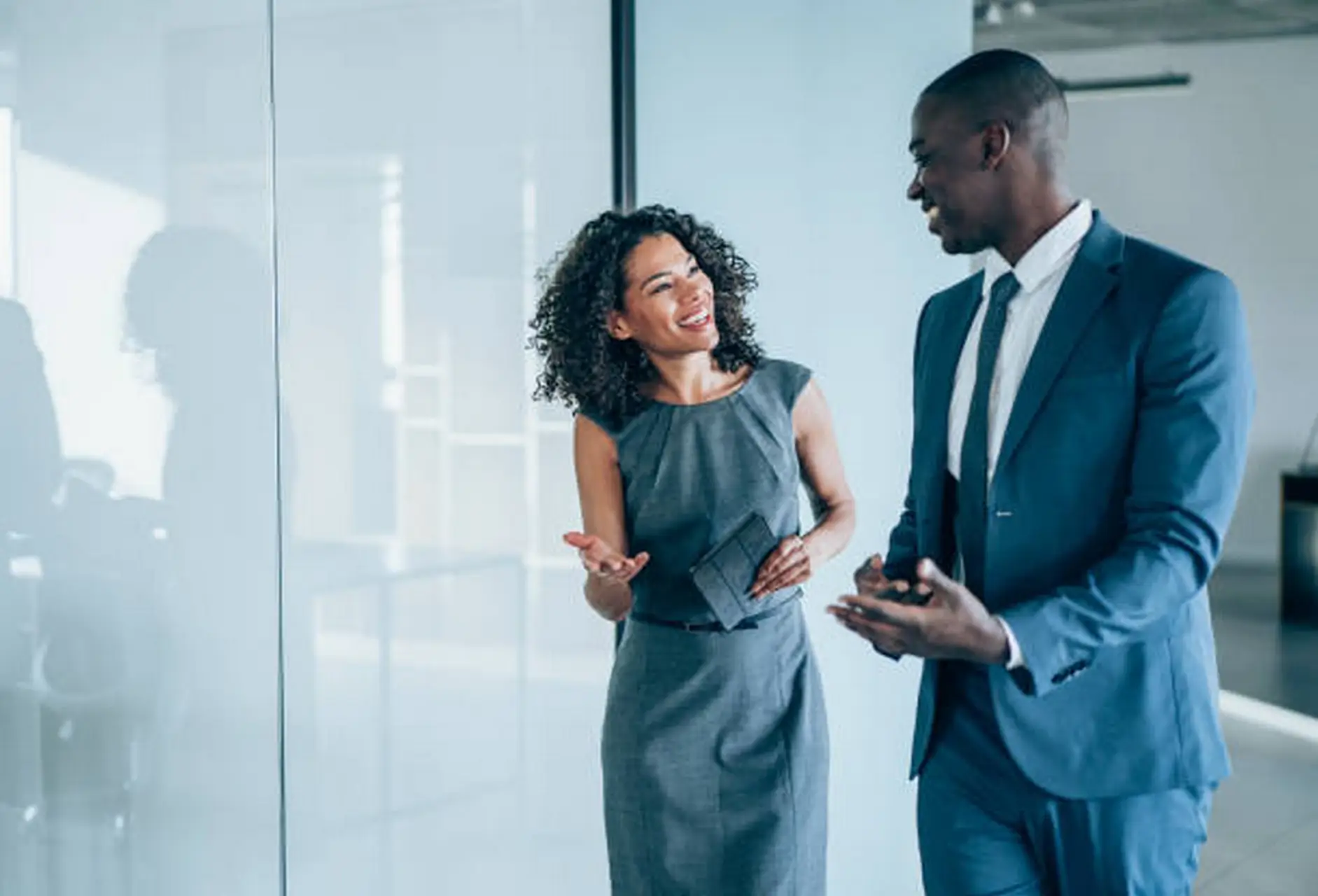 Two young colleagues having a fun discussion in a modern office