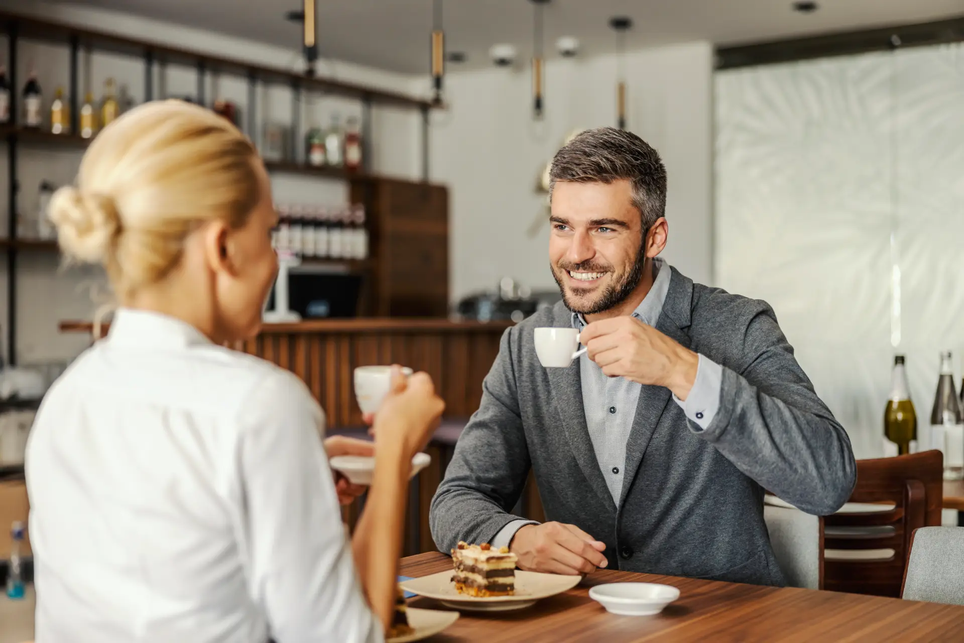 Coule enjoying a coffee and cake in a restaurant
